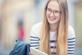 Portrait of a smiling beautiful teenage girl with dental braces. Young schoolgirl with school bag and tablet device Royalty Free Stock Photo