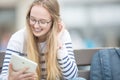 Portrait of a smiling beautiful teenage girl with dental braces. Young schoolgirl with school bag and tablet device Royalty Free Stock Photo