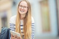 Portrait of a smiling beautiful teenage girl with dental braces. Young schoolgirl with school bag and tablet device Royalty Free Stock Photo