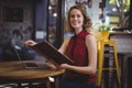 Portrait of smiling young woman holding file while sitting at coffee shop Royalty Free Stock Photo