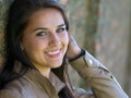 Portrait of a smiling, beautiful young woman leaning against a wall Royalty Free Stock Photo