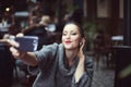 Portrait of a smiling beautiful young woman making selfie photo with her smartphone Royalty Free Stock Photo