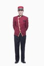 Portrait of Smiling Bellhop With Hands Behind Back, full length, studio shot Royalty Free Stock Photo