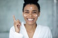 Portrait of smiling biracial female use face cream Royalty Free Stock Photo