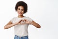 Portrait of smiling black beautiful woman, showing hand heart gesture, I love you sign, express romantic feelings Royalty Free Stock Photo