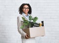 Portrait of happy black businesswoman with box of belongings starting new job at office Royalty Free Stock Photo