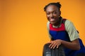Portrait of smiling black female mechanic posing with new car tyres in studio Royalty Free Stock Photo
