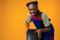 Portrait of smiling black female mechanic posing with new car tyres in studio Royalty Free Stock Photo