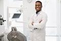 Portrait Of Smiling Black Stomatologist Doctor Wearing Uniform Posing In Clinic