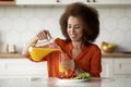 Portrait of smiling black woman having healthy breakfast in kitchen at home Royalty Free Stock Photo