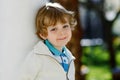 Portrait of smiling blond preschool boy, outdoors. Cute little child looking at the camera. Healthy happy kid. Royalty Free Stock Photo