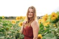 Portrait of smiling blond woman standing in field of sunflower during spring season Royalty Free Stock Photo