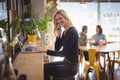 Portrait of smiling blond woman talking on mobile phone while using laptop Royalty Free Stock Photo