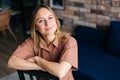 Portrait of smiling blonde woman sitting at chair in the living room. Royalty Free Stock Photo