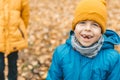 Portrait of a smiling boy in a hat and a blue jacket, Outdoors, against a background of yellow leave. Handsome and cute boy