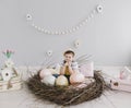 Portrait of a smiling boy in a hat. Easter composition with birds nest, easter eggs, dry willow branches. Royalty Free Stock Photo
