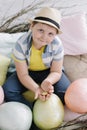 Portrait of a smiling boy in a hat. Easter composition with birds nest, easter eggs, dry willow branches. Royalty Free Stock Photo