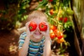 Portrait smiling boy holding red ripe tomatoes before his eyes i Royalty Free Stock Photo