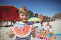 Portrait of smiling boy holding watermelon with family in background Royalty Free Stock Photo