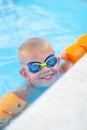 Portrait smiling boy in swimming pool, child in swimming glasses and inflatable sleeves. Summer travel hotel vacation or Royalty Free Stock Photo