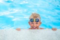 Portrait smiling boy in swimming pool, child in swimming glasses and inflatable sleeves. Summer travel hotel vacation or Royalty Free Stock Photo