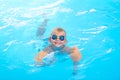 Portrait smiling boy in swimming pool, child in swimming glasses and inflatable sleeves. Summer travel hotel vacation or Royalty Free Stock Photo