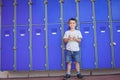 Portrait of smiling boy using mobile phone against lockers