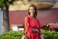 Portrait of a smiling brown haired woman standing on the street Royalty Free Stock Photo