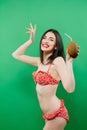 Portrait of Smiling Brunette in Bright Swimsuit with Tropical Cocktail in Hands on Green Background. Royalty Free Stock Photo