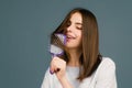 Portrait of smiling brunette hair lady combing hair with hairbrush comb, isolated. Young beautiful woman brush long Royalty Free Stock Photo