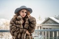 Portrait of smiling brunette woman wearing fur mink winter coat and grey hat Royalty Free Stock Photo