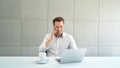 Portrait of smiling business blonde, white man, Caucasian person using laptop computer, working, and talking on smart mobile phone Royalty Free Stock Photo