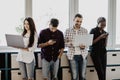 Portrait of smiling business colleagues using mobile phone and laptop in office Royalty Free Stock Photo