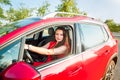 Portrait of smiling business lady, caucasian young woman driver in red clothes looking at camera and smiling while sitting behind Royalty Free Stock Photo