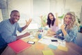 Portrait of smiling business people gesturing while sitting at desk Royalty Free Stock Photo