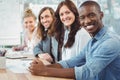 Portrait of smiling business people sitting in row at desk Royalty Free Stock Photo