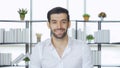 Portrait of smiling business, Turkish man with beard working from home and talking to his colleagues in webcam group video call