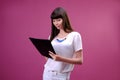 Portrait of smiling business woman with pen and paper folder. Young pretty worker writing something in her papers Royalty Free Stock Photo