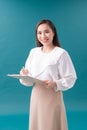 Portrait of smiling business woman with pen and paper folder. Young pretty worker writing something in her papers Royalty Free Stock Photo