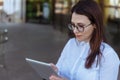 Portrait of smiling business woman using tablet pc in front of office building. Royalty Free Stock Photo