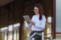 Portrait of smiling business woman using tablet pc in front of office building. Royalty Free Stock Photo