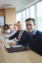 Portrait of smiling businessman with colleagues sitting at office Royalty Free Stock Photo