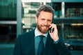 Portrait of smiling businessman outdoors. Closeup of happy mature business man outdoor. Urban man talking on smart phone Royalty Free Stock Photo