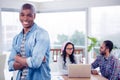 Portrait of smiling businessman standing with arms crossed in office Royalty Free Stock Photo