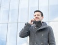Portrait of smiling businessman talking by phone, outdoor.