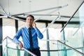 Smiling businessman using smartphone while standing at office Royalty Free Stock Photo