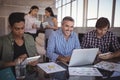 Portrait of smiling businessman working on laptop at creative office Royalty Free Stock Photo