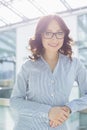 Portrait of smiling businesswoman leaning on railing in office Royalty Free Stock Photo