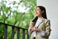 Portrait of smiling businesswoman standing on the balcony of a modern office, enjoying contemplation nature view Royalty Free Stock Photo