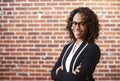 Portrait Of Smiling Businesswoman Wearing Glasses Standing Against Brick Wall In Modern Office Royalty Free Stock Photo